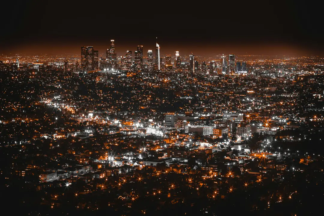 The towers of downtown Los Angeles glowing amber above the city lights at night