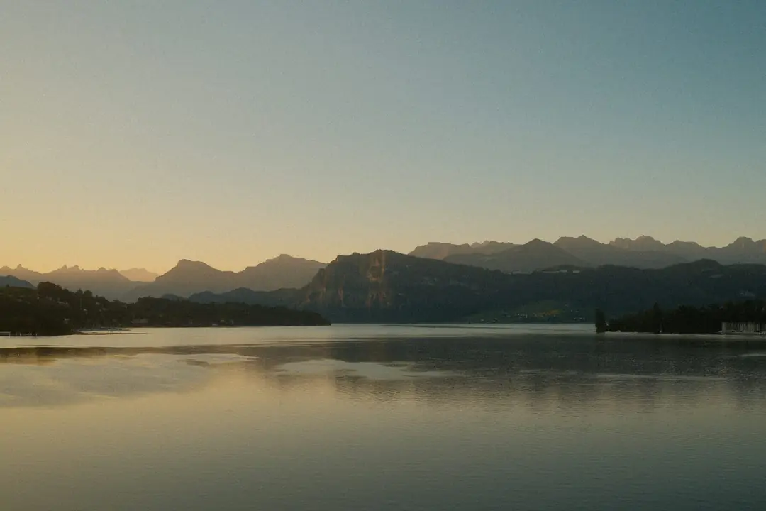 Mountains reflected in the still water of Lake Lucerne in the soft evening light