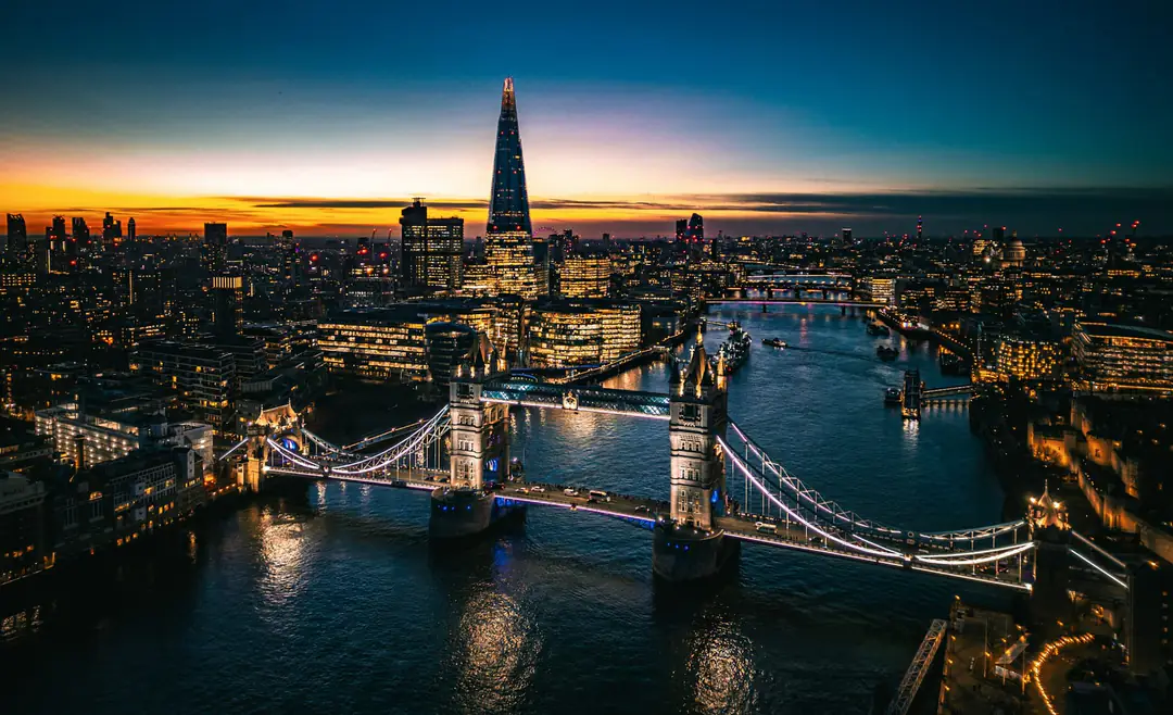 Tower Bridge and the Thames lit at dusk, with the Shard against the last light