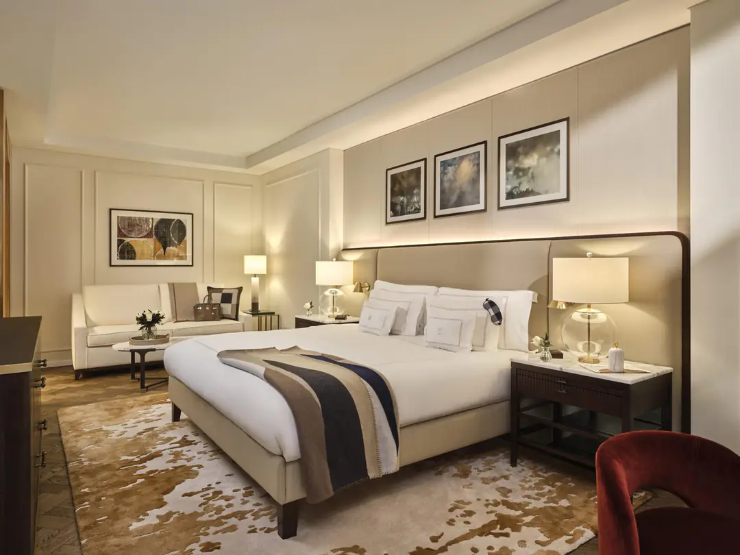 Whitehall Suite bedroom: a king bed with a striped throw, a cream sofa behind and a cowhide-pattern rug