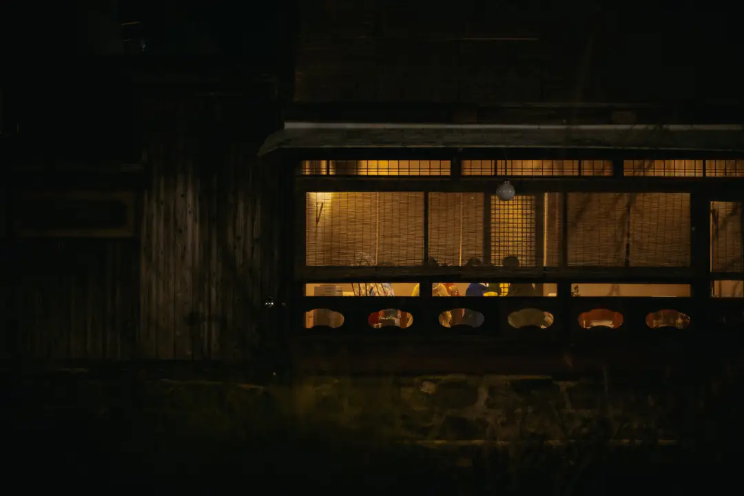 Warm light glowing through a wooden-framed window at night