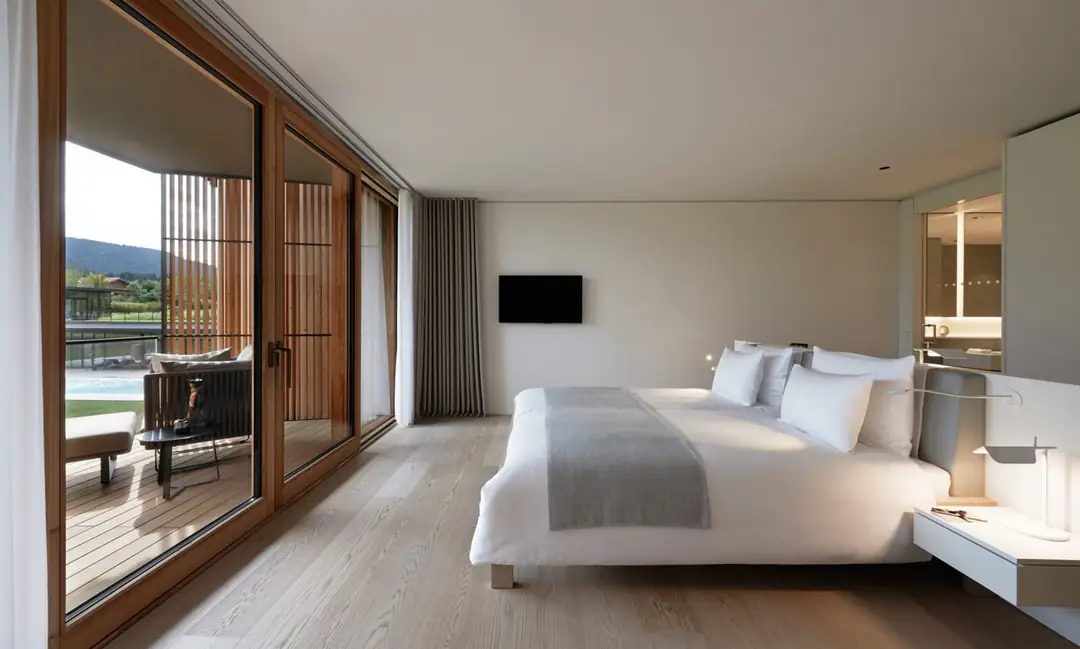 Double Room with a white bed, oak parquet and wood-framed glass doors open to a terrace