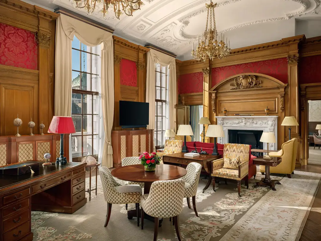 Suite sitting room with oak panelling, red damask, plaster ceiling and tall sash windows