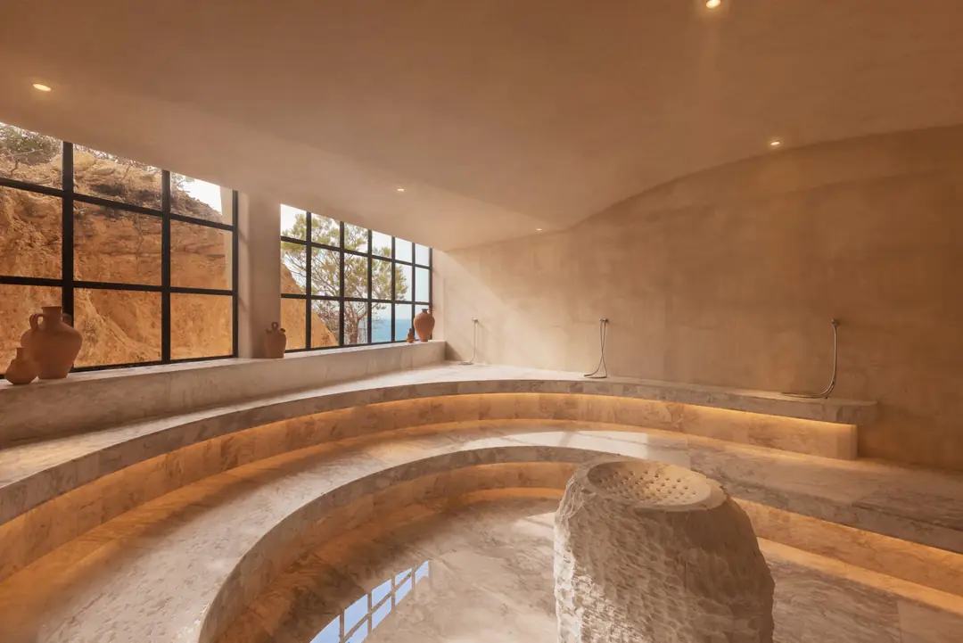 Curved stone benches in the spa's steam room, with windows onto the rock face